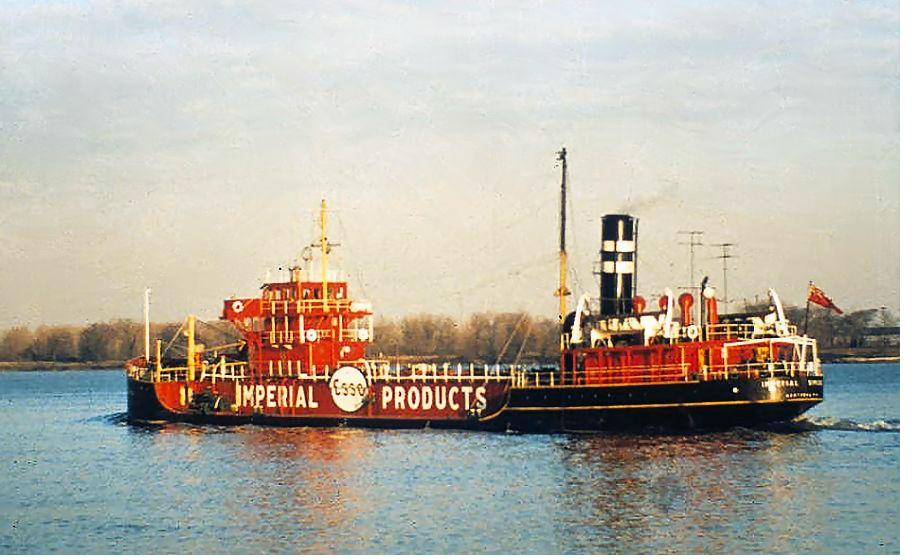 A black-hulled tanker lettered Imperial Products under way in low sun.