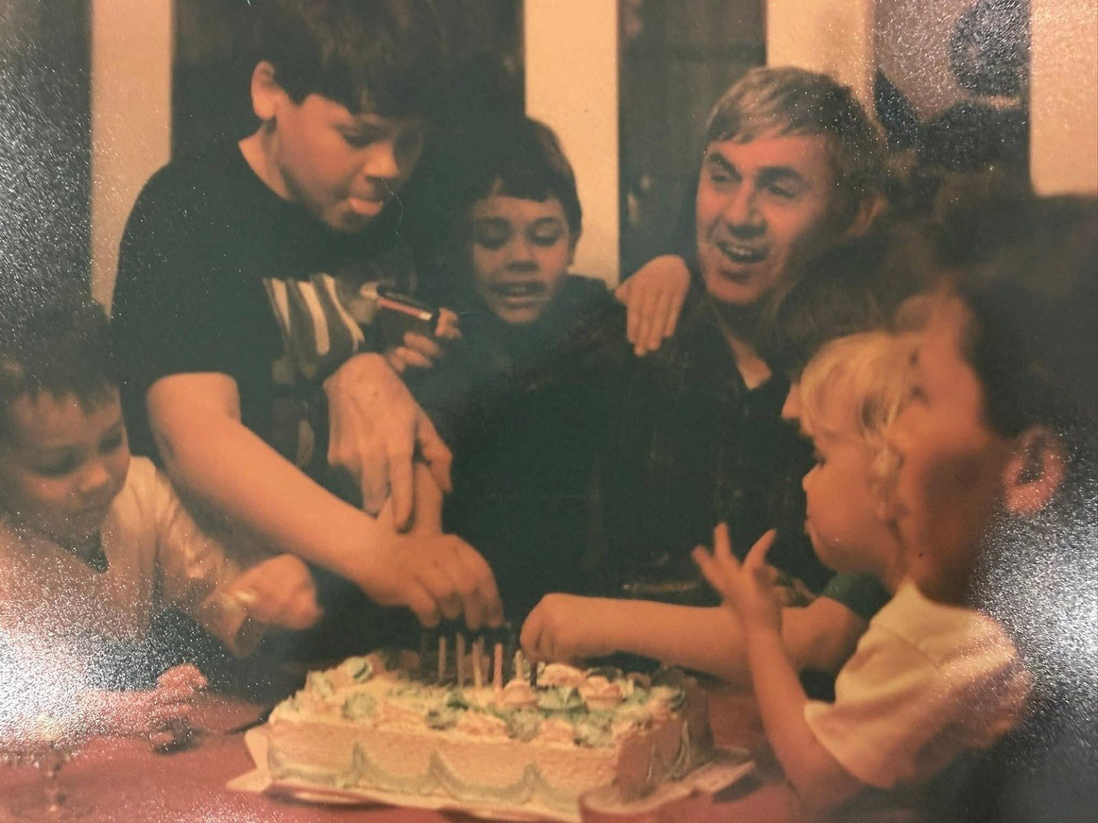 Robert Davies surrounded by grandchildren at a birthday dinner