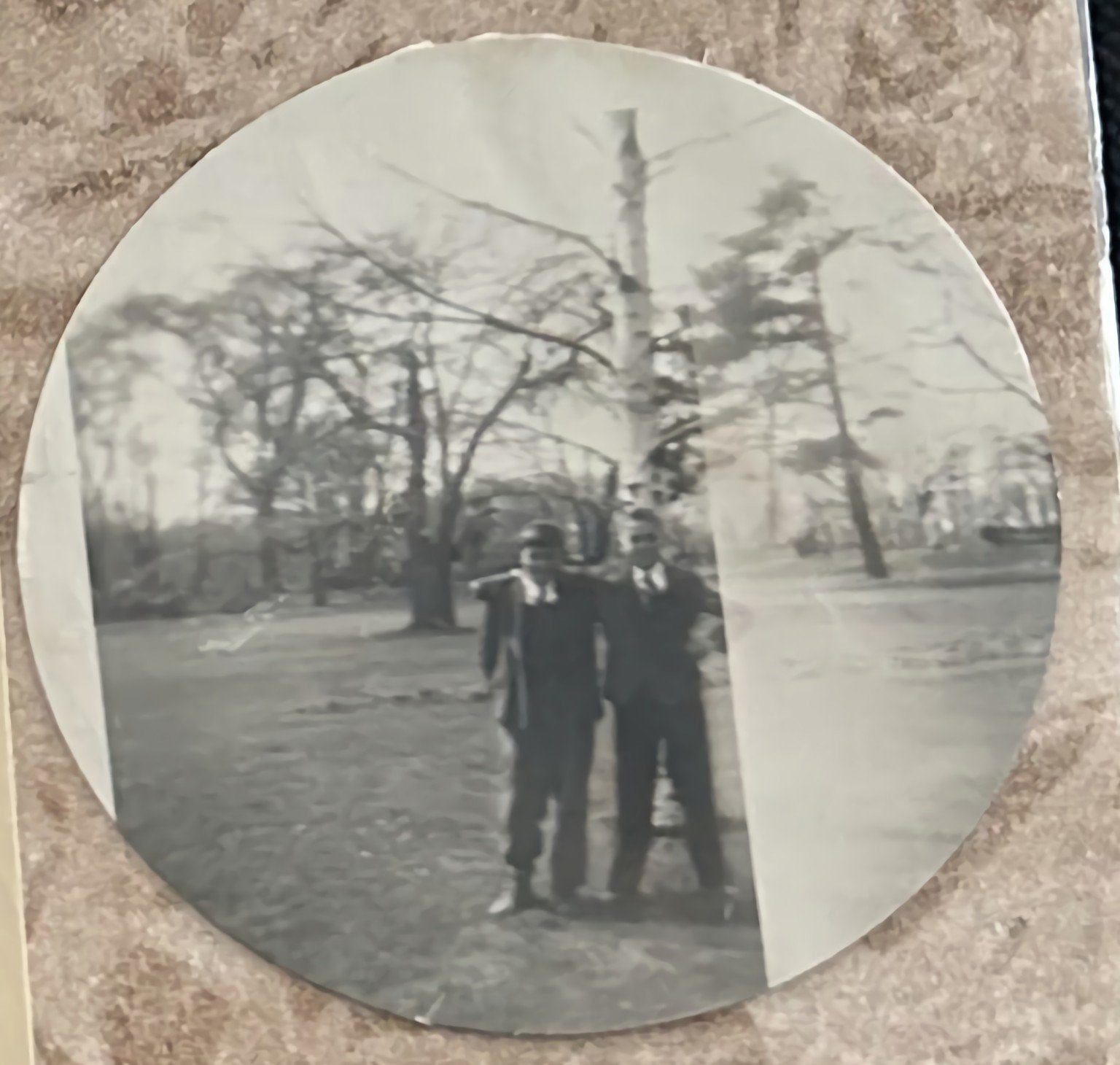 Circular black-and-white photograph of two young men in an unidentified location